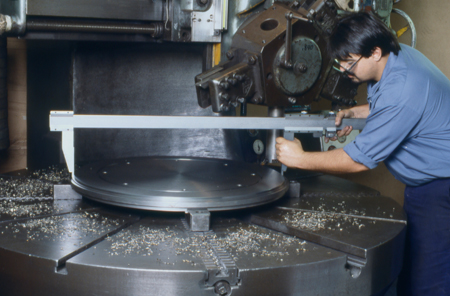 UTRS AM technician inspecting a large piece on turning machine