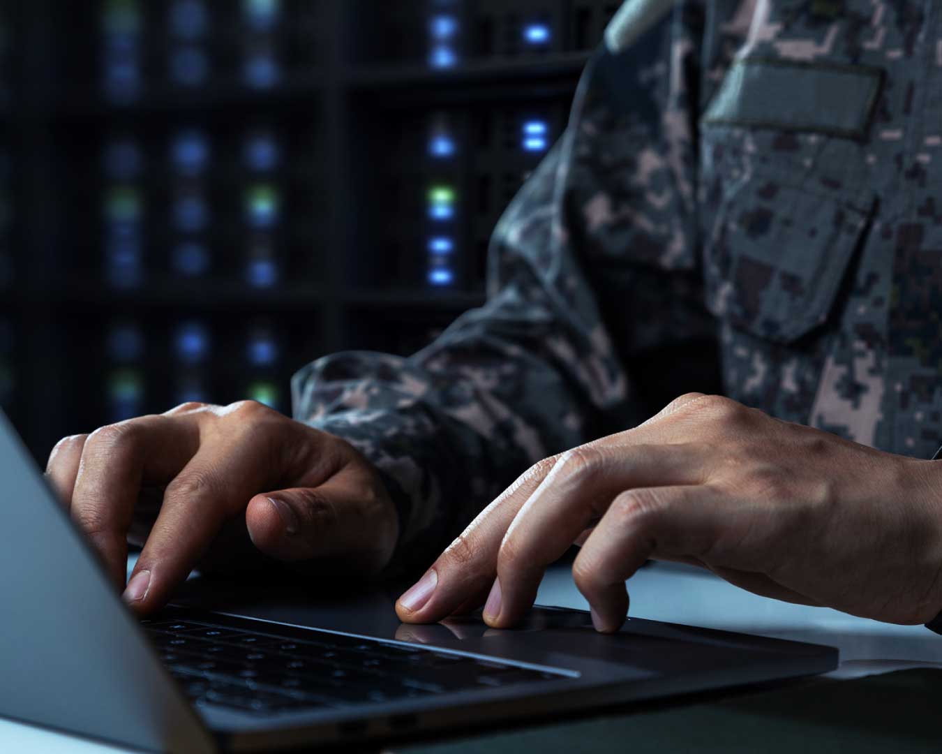 Soldier in camouflage uniform working on laptop for cybersecurity Operation.