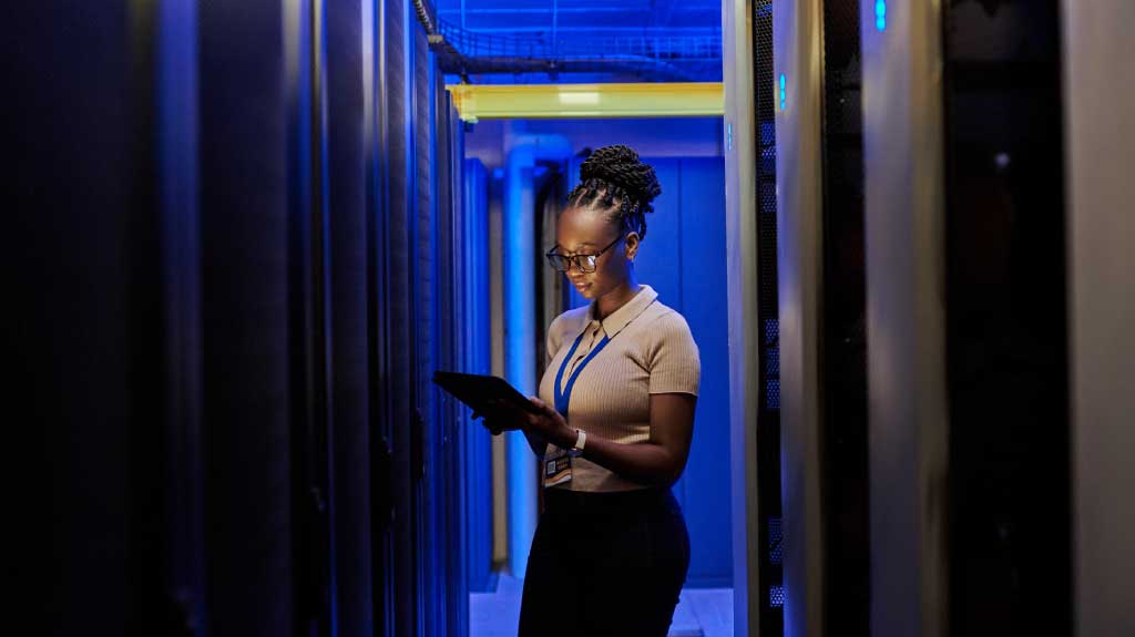 Shot of a young African female engineer using a digital tablet while working in a server room