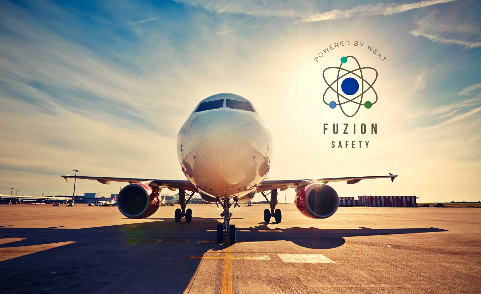 Airplane sitting on runway on a sunny day with Fuzion Safety logo.