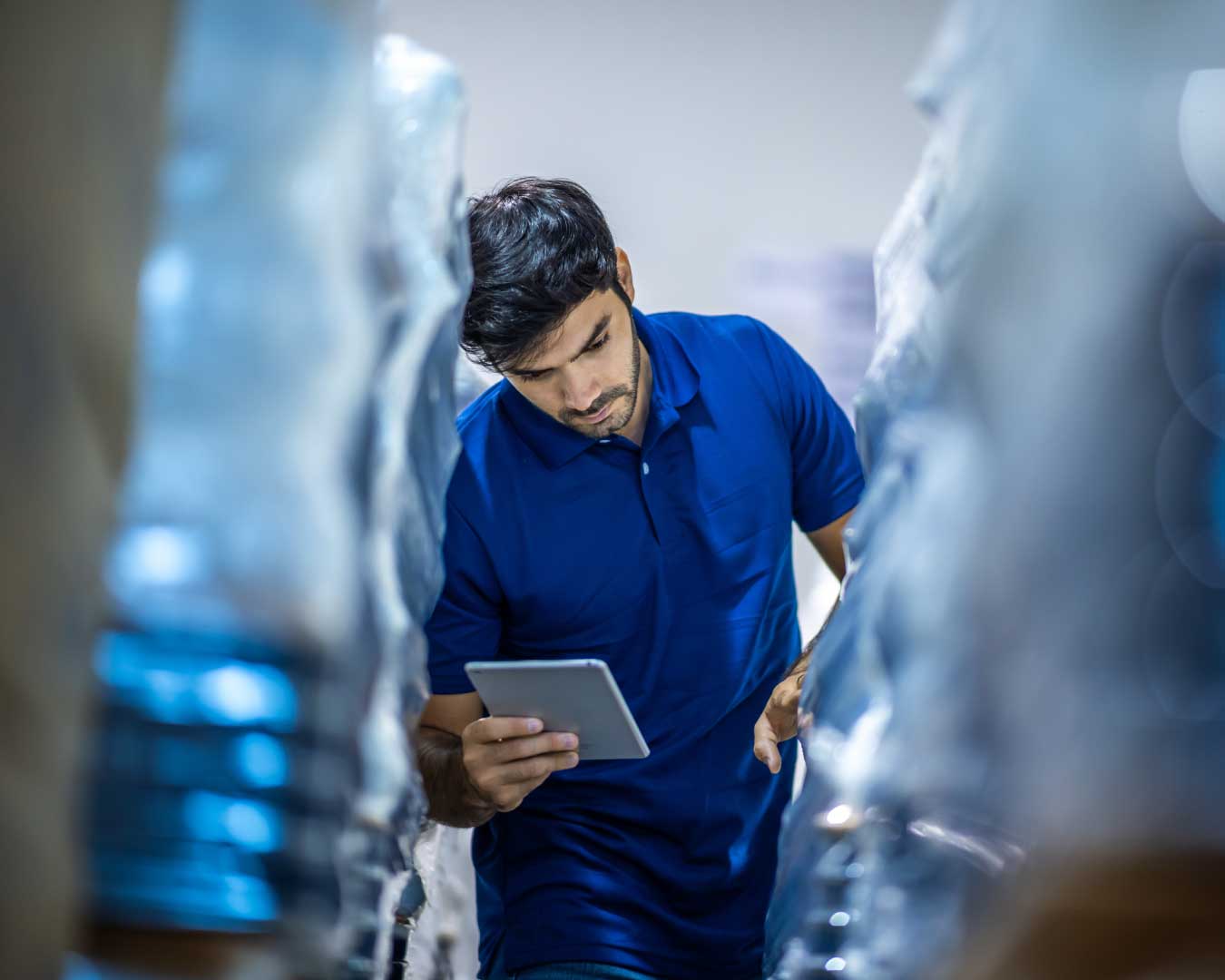 Male warehouse worker working for check and analyze newly arrived goods for further placement in storage department.