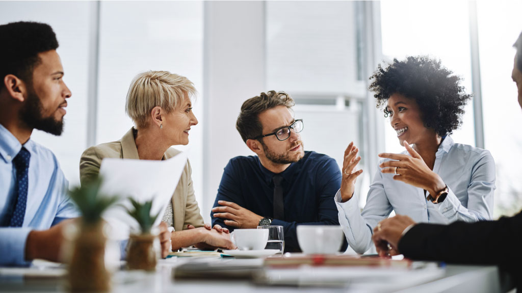 Small group meeting of corporate employees in conversation.