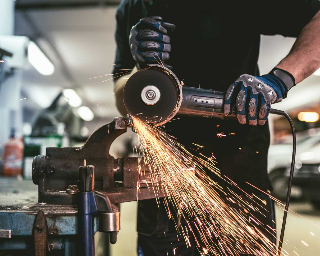 Heavy industry worker cutting steel with an angle grinder.